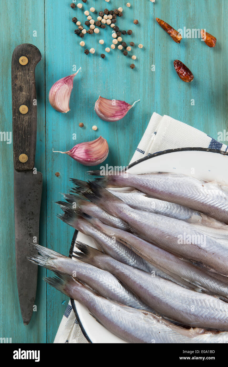 Eine Platte mit Fisch auf dem Küchentisch und Zutaten zu kochen. Stockfoto