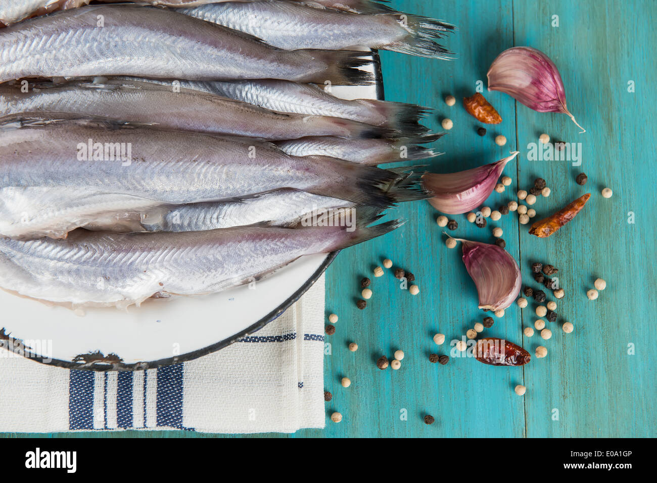 Eine Platte mit Fisch auf dem Küchentisch und Zutaten zu kochen. Stockfoto