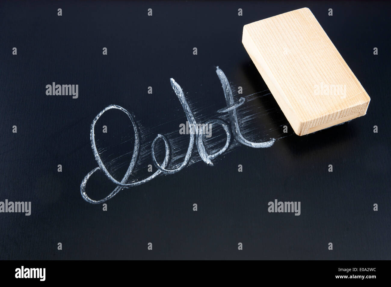 Das Wort Schulden Kreide auf eine Tafel geschrieben ausradiert durch einen Radierer Stockfoto