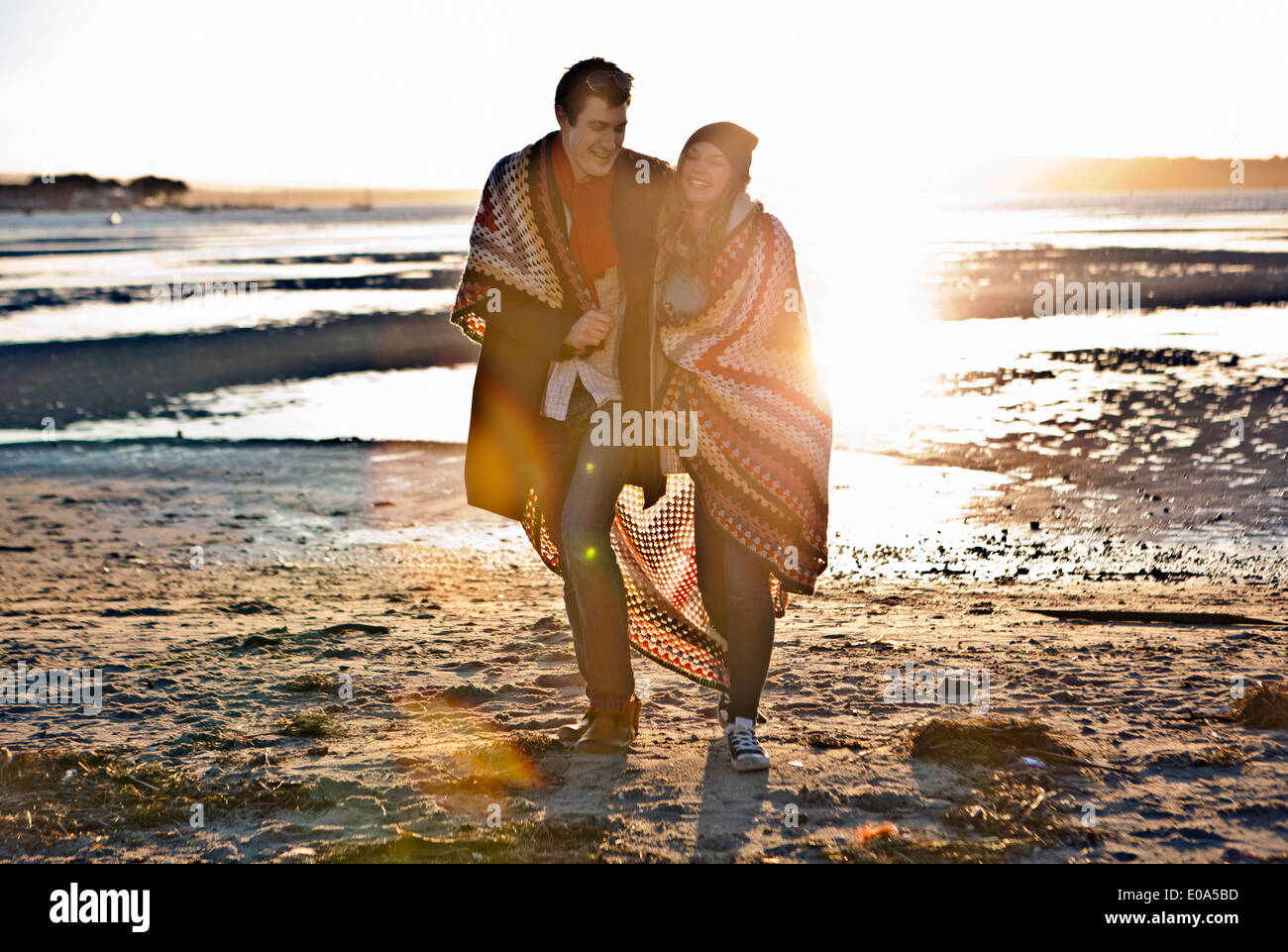 Paar, eingewickelt in eine Decke zu Fuß am Strand Stockfoto