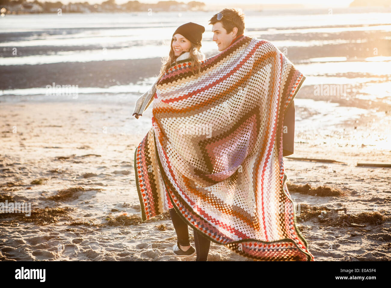 Paar, eingewickelt in eine Decke, ein Spaziergang am Strand Stockfoto