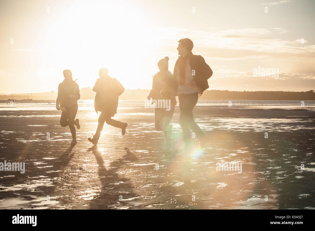 Erwachsene Freunde Rennen einander am Strand Stockfoto