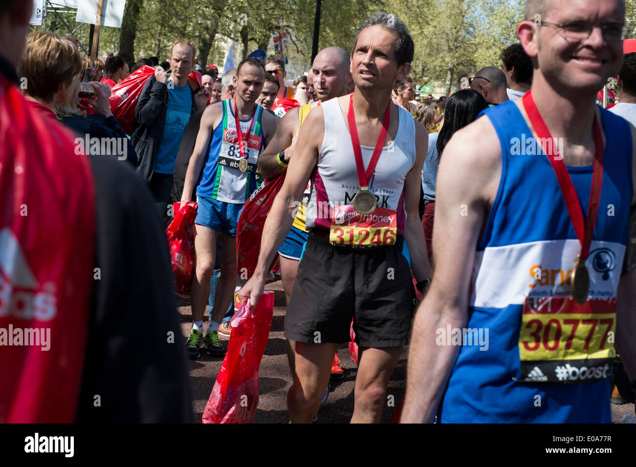 Wettbewerber in den London-Marathon 2014. Läufer mit ihren Medaillen und Goody Taschen im Zielbereich. Stockfoto