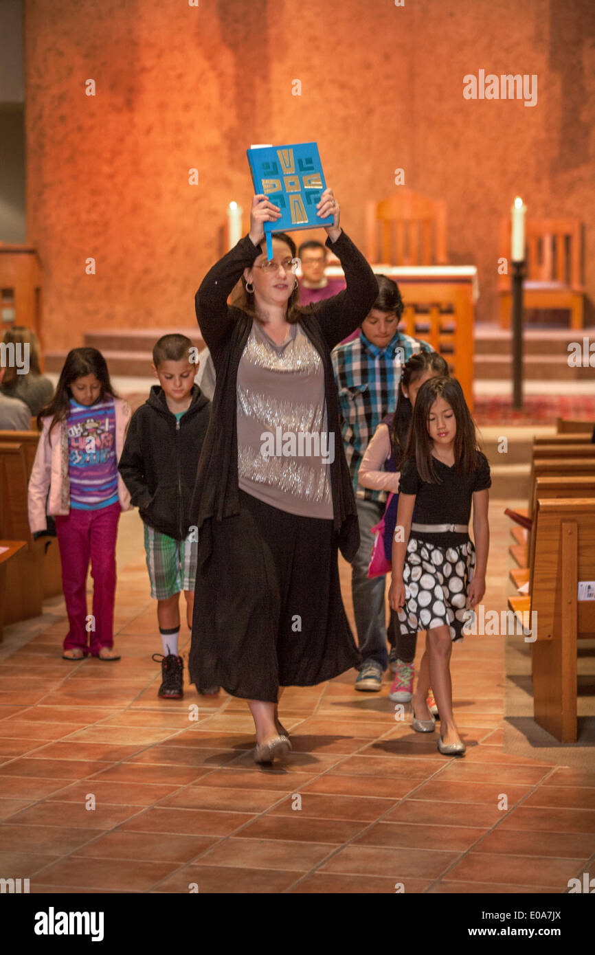 Im Anschluss an das Anfangsgebet an Masse Kinder Gemeindemitglieder sind führen zu ein spezielles Kindermenü Wortgottesdienst am Laguna Niguel, CA, katholische Kirche. Beachten Sie die Bibel von Führer durchgeführt. Stockfoto