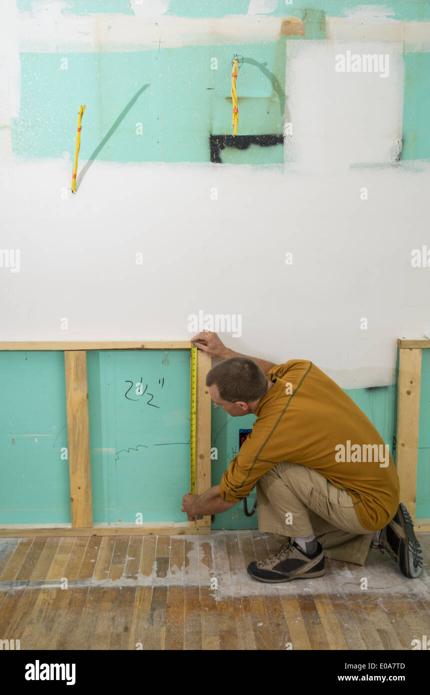 Mann bei der Arbeit an einer Küche umgestalten mit Maßband messen Stockfoto