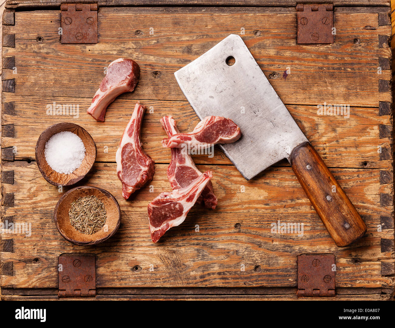 Rohes, frisches Lamm Rippen und Fleischerbeil auf hölzernen Hintergrund Stockfoto
