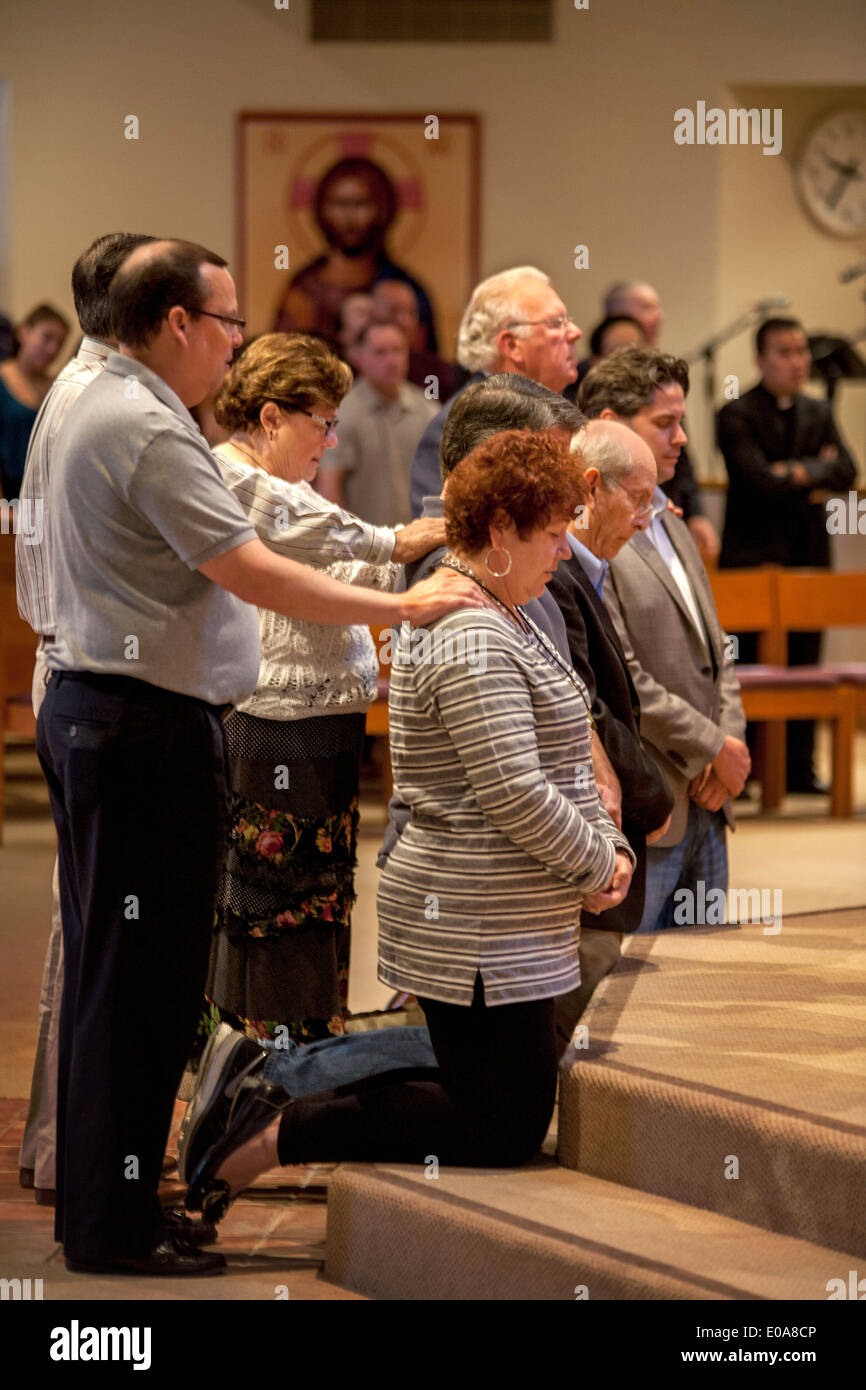 Katechumenen oder Menschen, die Katholiken, werden Knien mit ihren Sponsoren vor einem Priester für die Prüfung in einer katholischen Kirche in Laguna Niguel, CA. Stockfoto