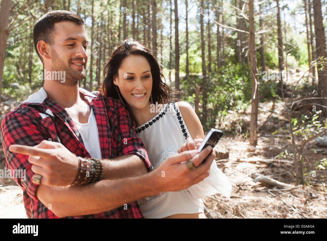 Junges Paar im Wald, Mann zeigte Stockfoto
