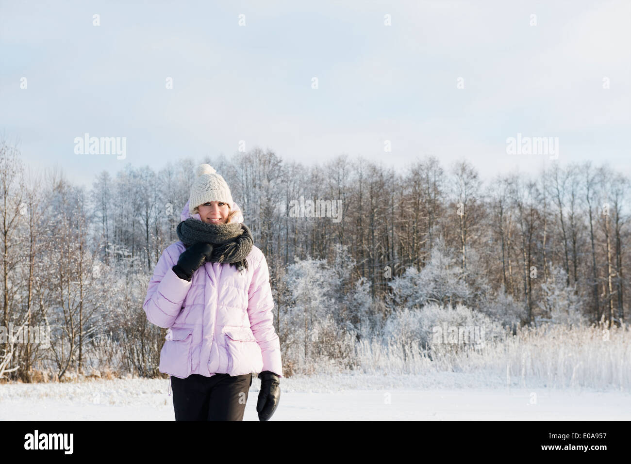 Mitte Erwachsene Frau tragen Winterkleidung im Schnee bedeckt Feld Stockfoto