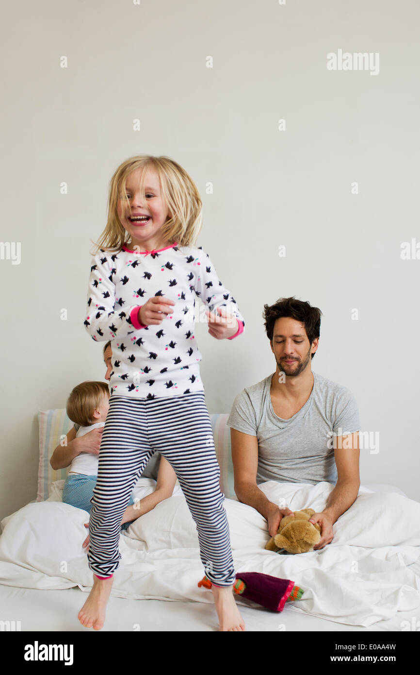 Junges Mädchen springen auf ihrem Bett der Eltern Stockfoto