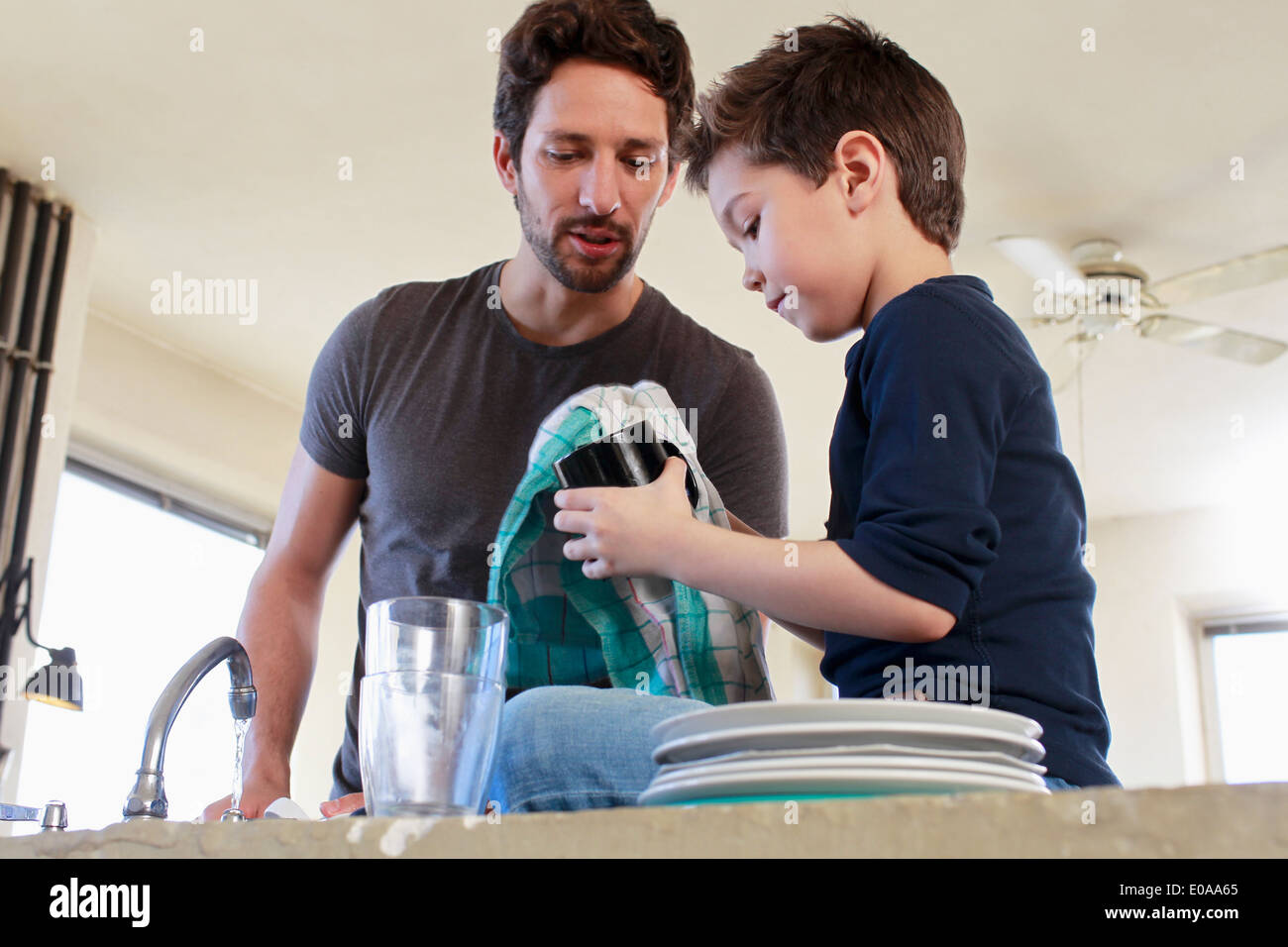 Vater und Sohn tun Abwasch erledigen Stockfoto