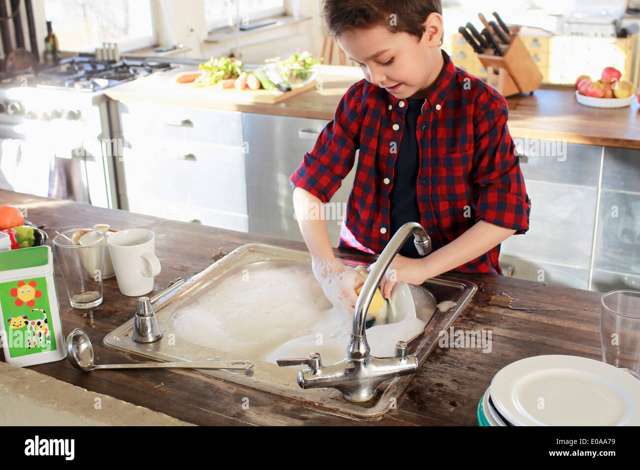 Kleiner Junge waschen in Küche Stockfoto