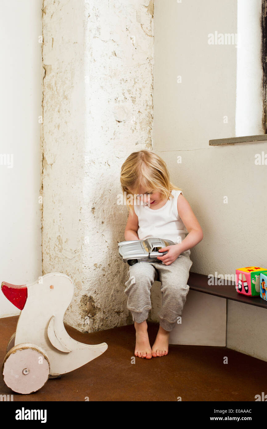 Junge Mädchen spielen mit Spielzeug-Auto im Korridor Stockfoto