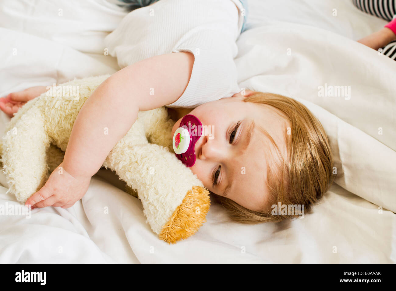 Babymädchen schläft mit Teddybär Stockfoto