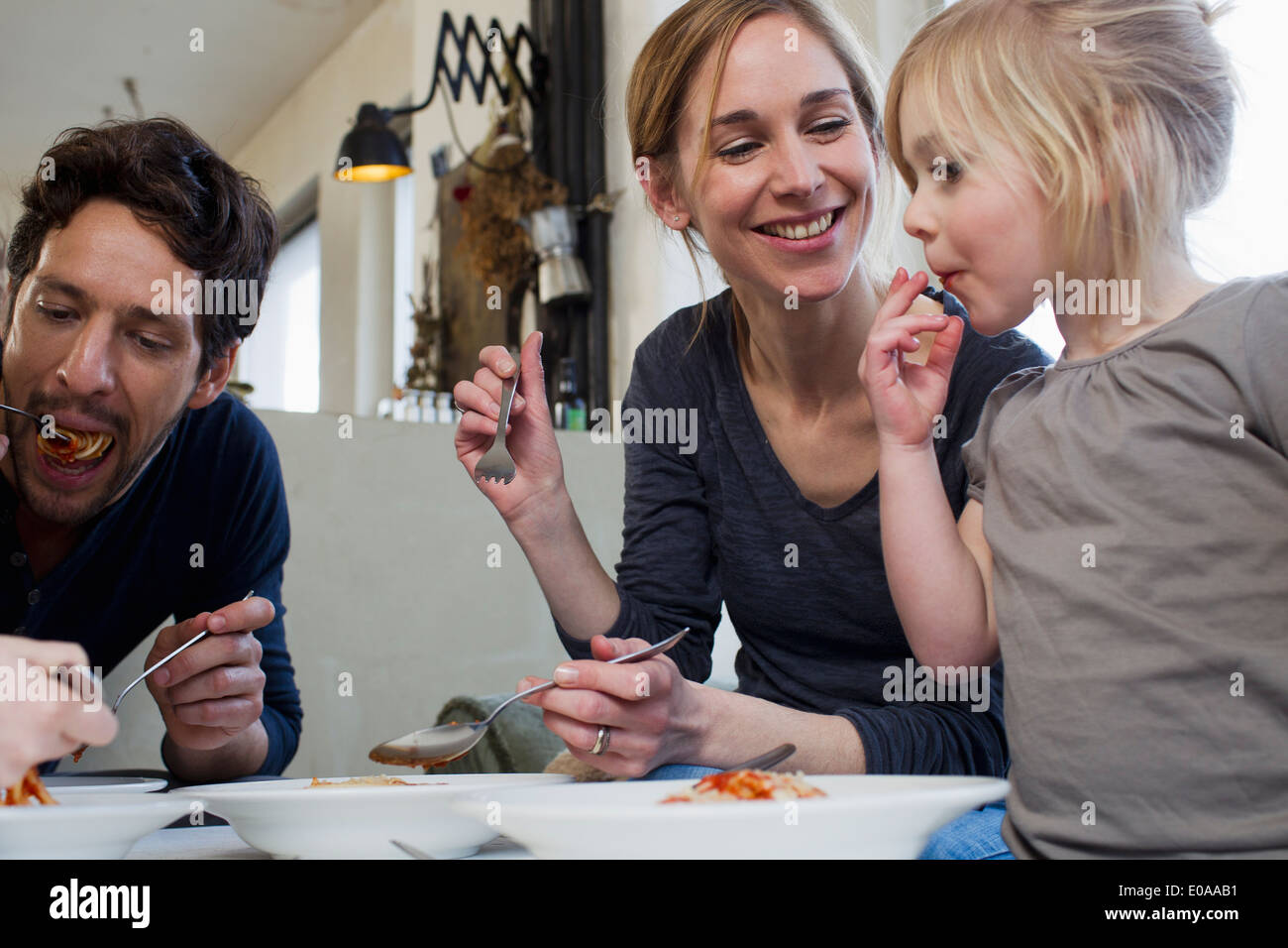 Mitte Erwachsenen Eltern und zwei Töchtern Essen ein spaghetti Stockfoto