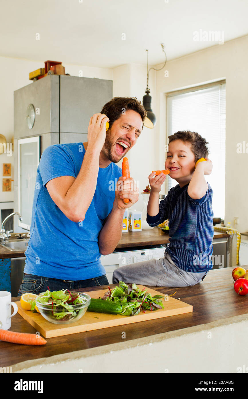 Vater und seinem kleinen Sohn in Karotte Mikrofone zu singen Stockfoto