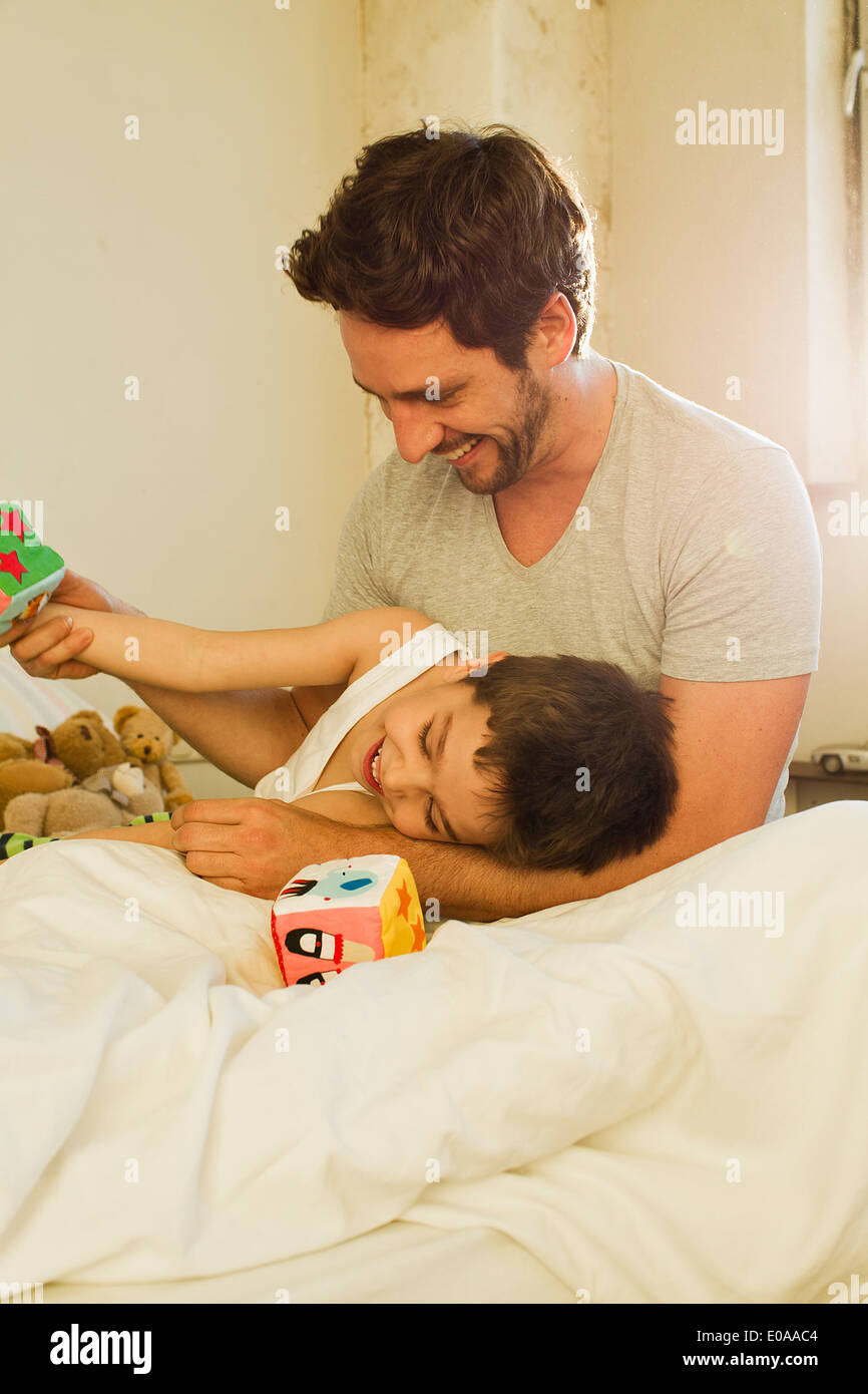 Vater und seinem kleinen Sohn spielen auf Bett Stockfoto