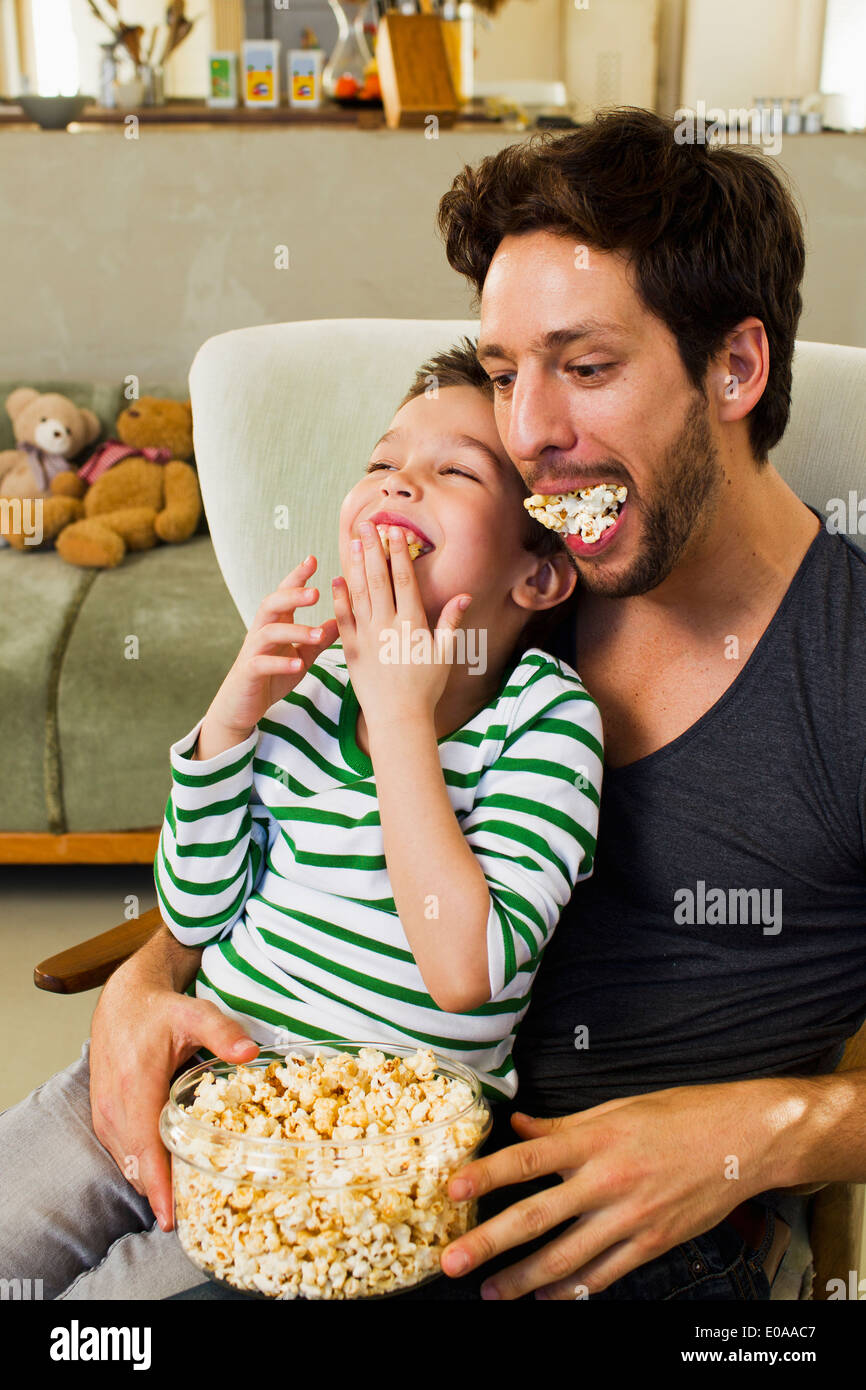 Vater und seinem kleinen Sohn mit Bissen von popcorn Stockfoto