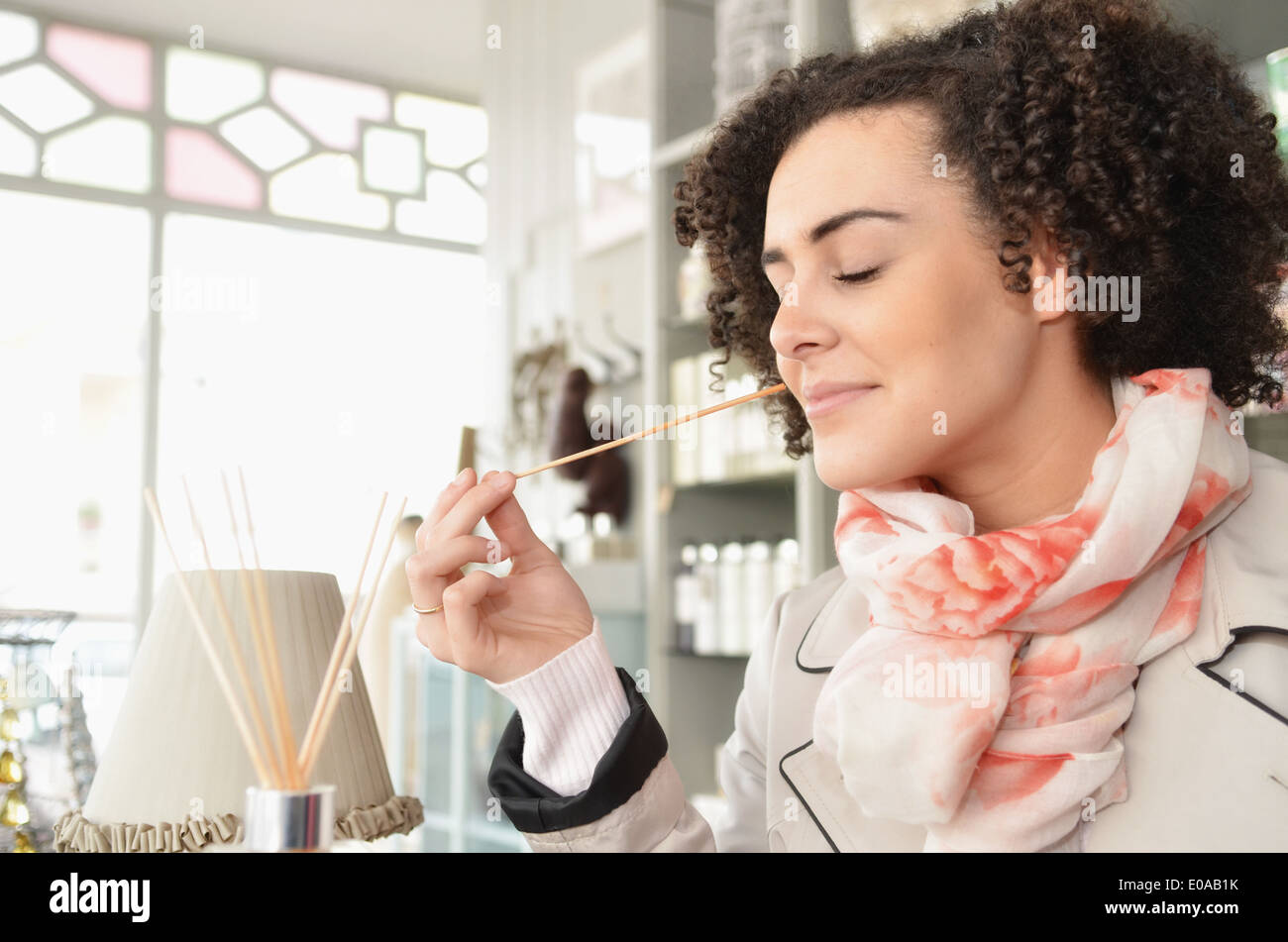 Junge Frau duftende Räucherstäbchen in boutique Stockfoto