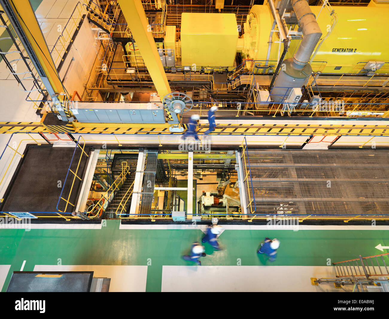 Arbeiter in der Turbinenhalle des Kraftwerks, erhöhte Ansicht Stockfoto