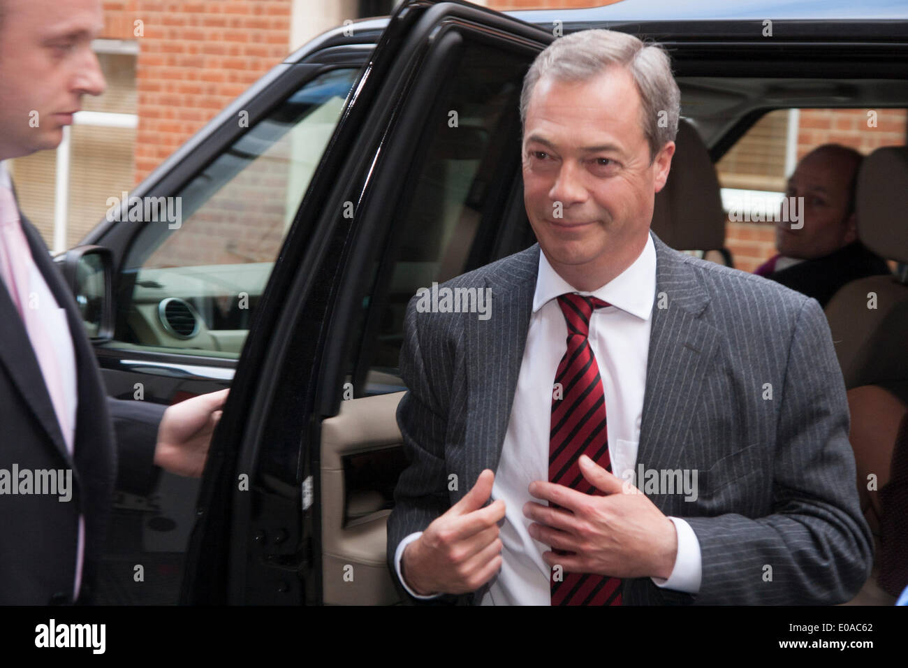 London, 7. Mai 2014. Der UKIP Nigel Farrage gelangt über einen Hintereingang wie Antirassismus Demonstranten außerhalb der Emmanuel Centre in Westminster zu demonstrieren, wie Ticketinhaber, vor seiner Ankunft an ihrer London-Kundgebung in die Warteschlange. Bildnachweis: Paul Davey/Alamy Live-Nachrichten Stockfoto