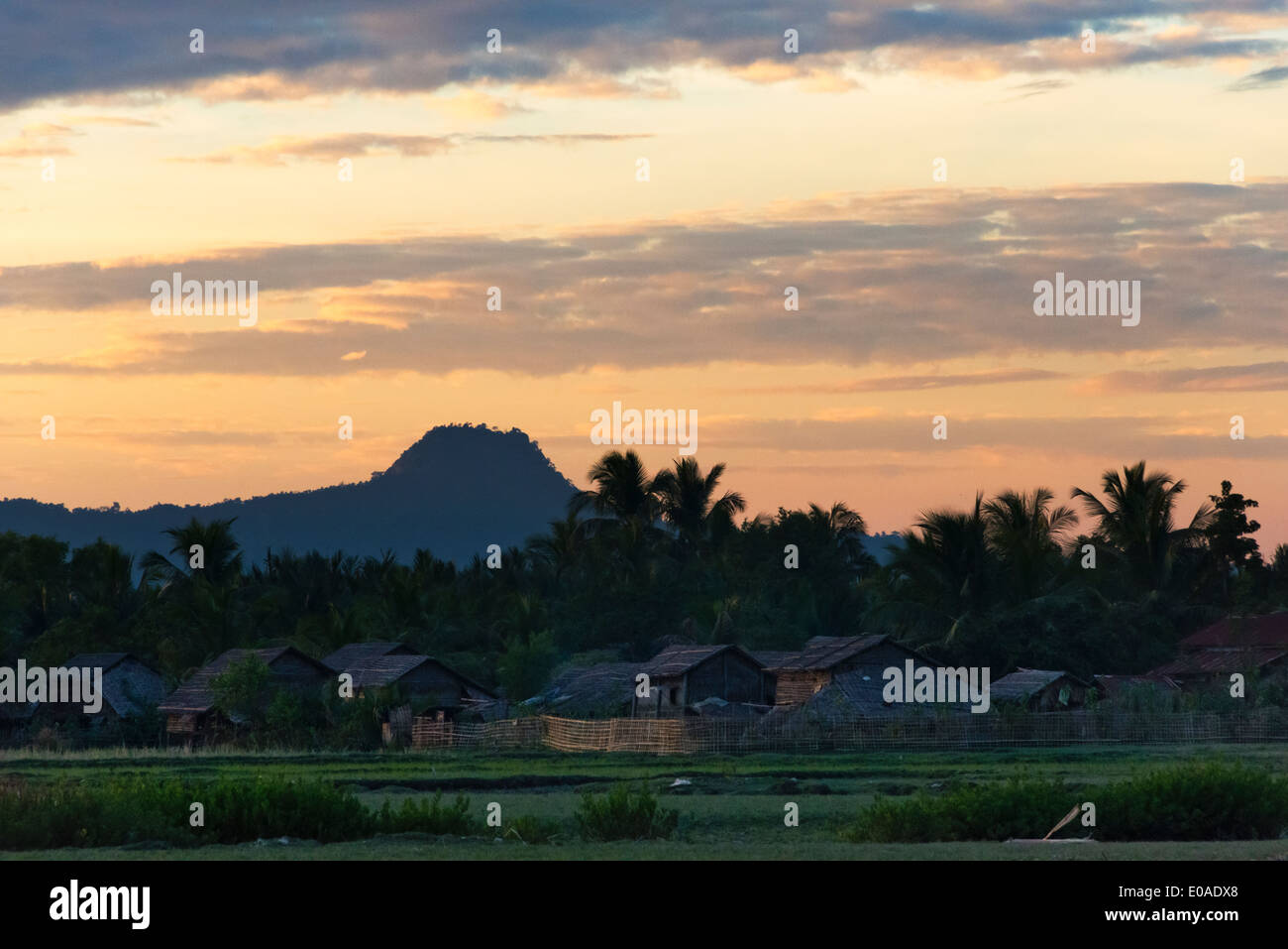 Bambushaus mit Palm Leaf Dach entlang des Flusses Kaladan bei Sonnenuntergang, Sittwe, Rakhine State in Myanmar Stockfoto