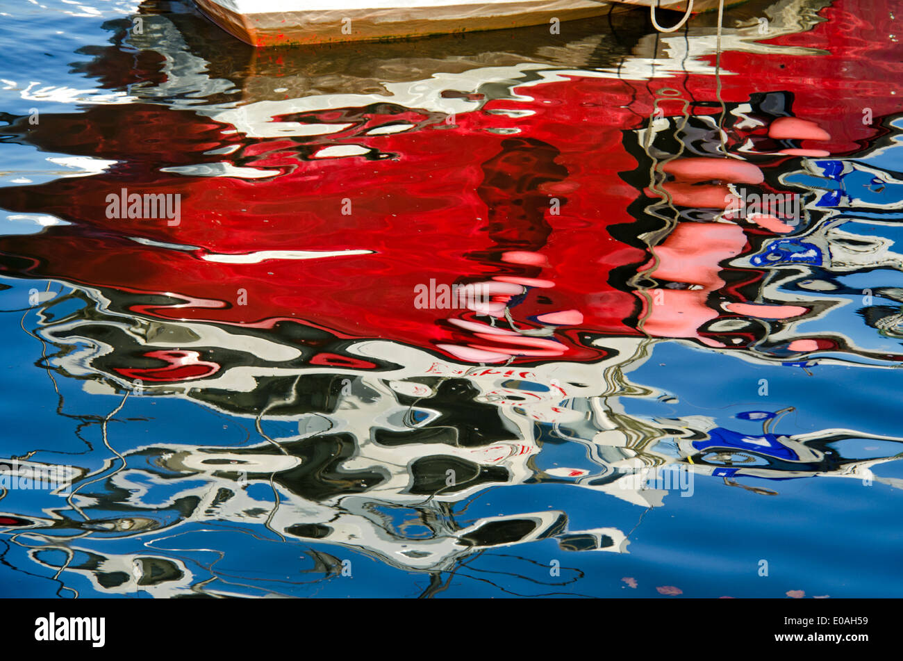 Roten, weißen und blauen Reflexionen eines Bootes und Himmel bei Newhaven Harbour, Edinburgh, Schottland, UK. Stockfoto