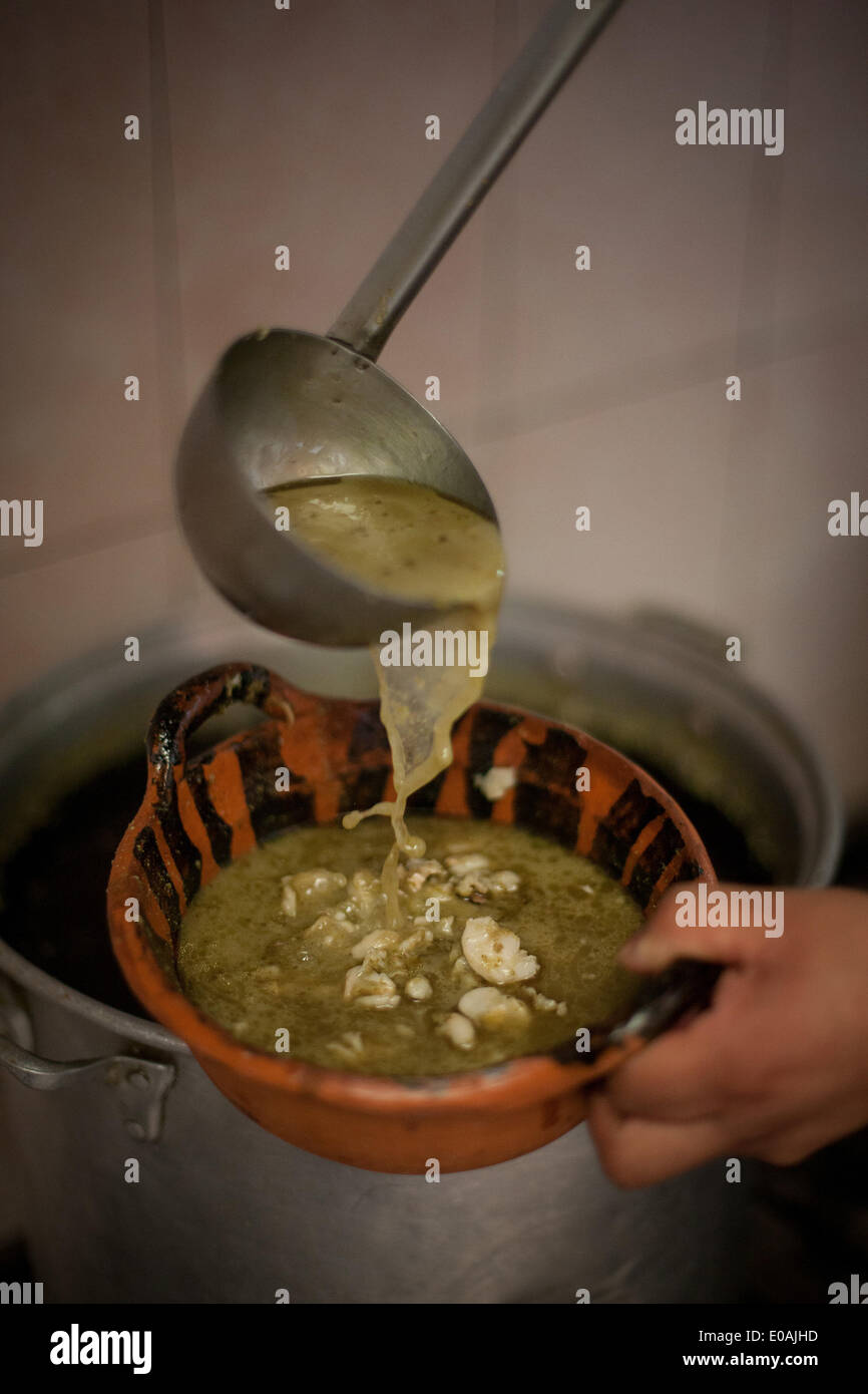 (140507)--Mexiko-Stadt, 7. Mai 2014 (Xinhua)--A Mann dient ein Teil des "Pozole" (Maissuppe) im Pozoleria Tixtla Restaurant in Mexiko-Stadt, Hauptstadt von Mexiko, am 7. Mai 2014. Die Pozole ist ein traditionelles Gericht, das in den Bundesstaaten Guerrero, Michoacán, Jalisco, Nayarit, Sinaloa u.a. bereit ist. Sein Ursprung geht zurück zu vorspanischen Zeiten. Unter den verschiedenen Rezepten, Pozole vorzubereiten hat der Staat Guerrero die Besonderheit, grün, weil sie mit einer Mischung aus traditionellen Molesoße Grünfärbung, Chicharron (Schwarten), Sardine und rohes Ei bereit ist. (Xinhua/Pedro mich Stockfoto