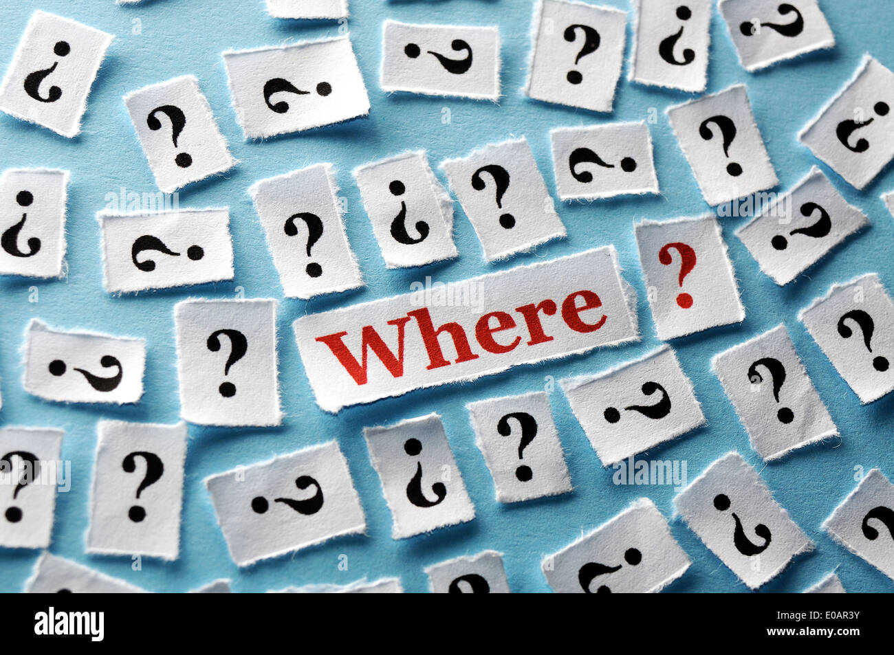 viele Fragezeichen auf weißem Papier - hart Licht Stockfoto