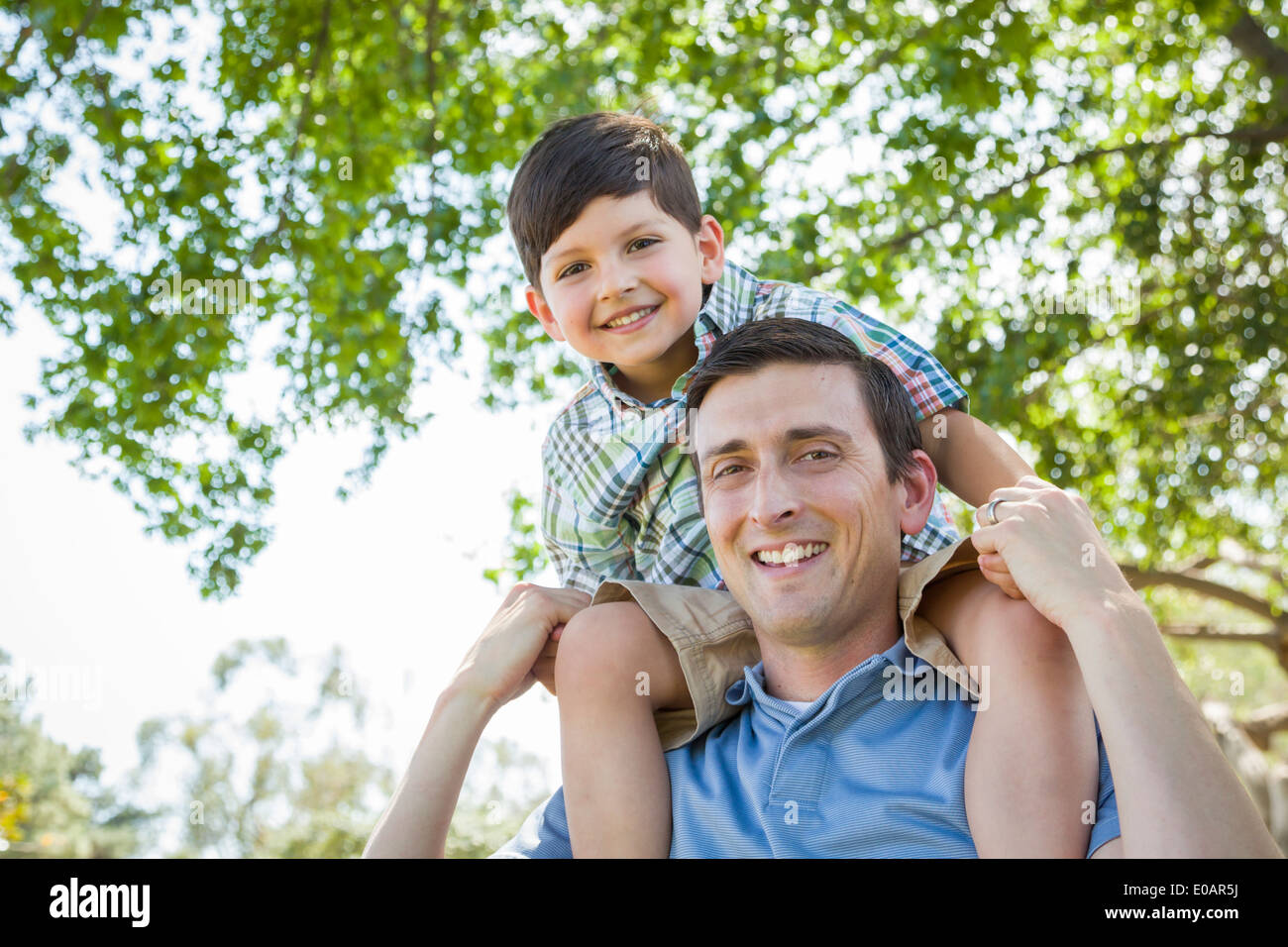 Gemischte Rennen-Vater und Sohn spielen zusammen im Park Huckepack. Stockfoto