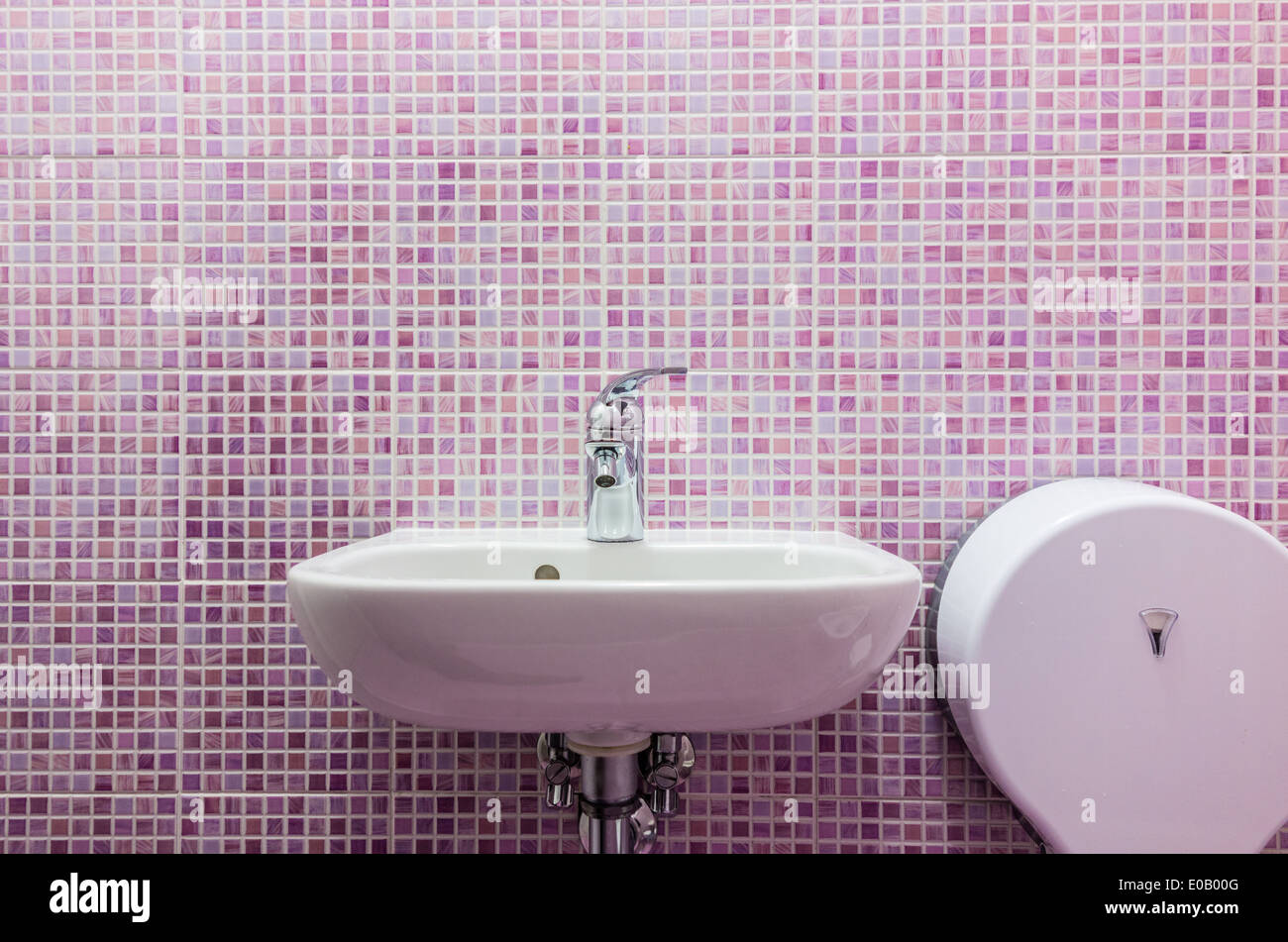 ein sauberes weißes Waschbecken im Badezimmer mit rosa gekachelten Wänden Stockfoto