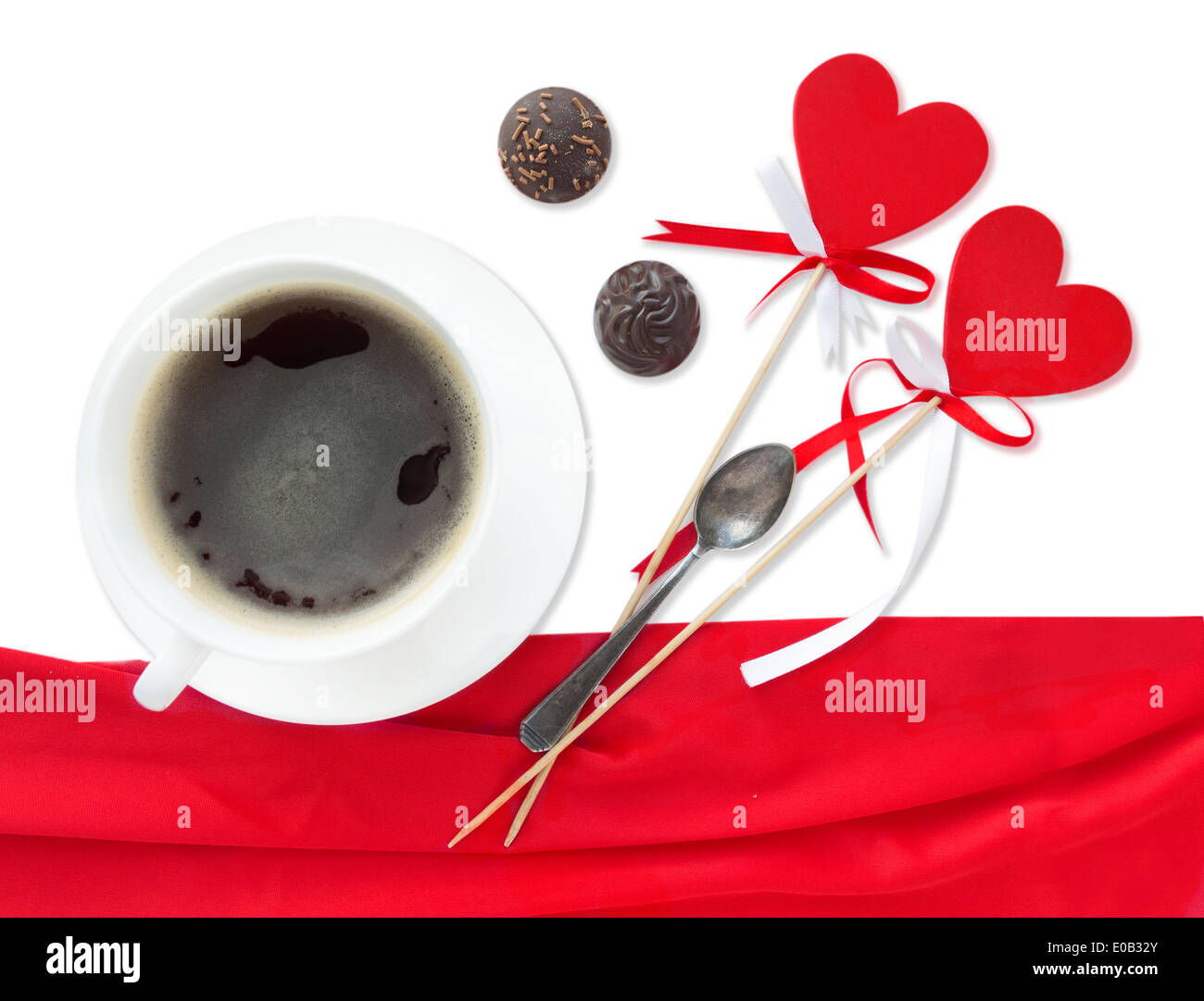 Zwei Lutscher Herzen mit Bogen, Tasse Kaffee und Pralinen, isoliert auf weiss Stockfoto