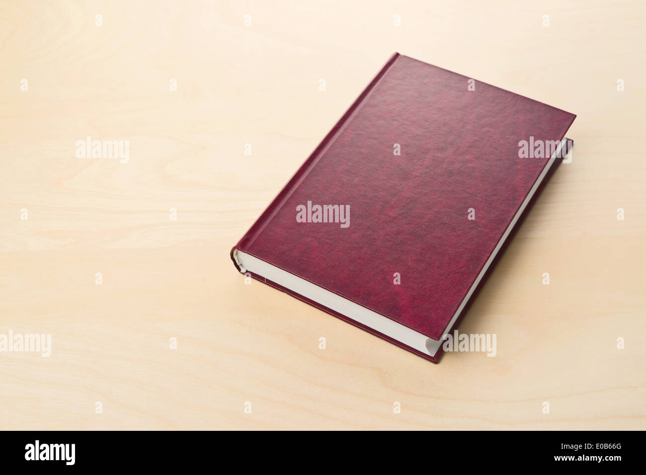 Neue rote Hardcover-Buch mit Blindabdeckung auf Tisch Stockfoto