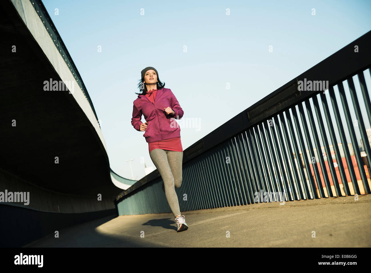 Junge weibliche Jogger unterwegs auf einer Brücke Stockfoto
