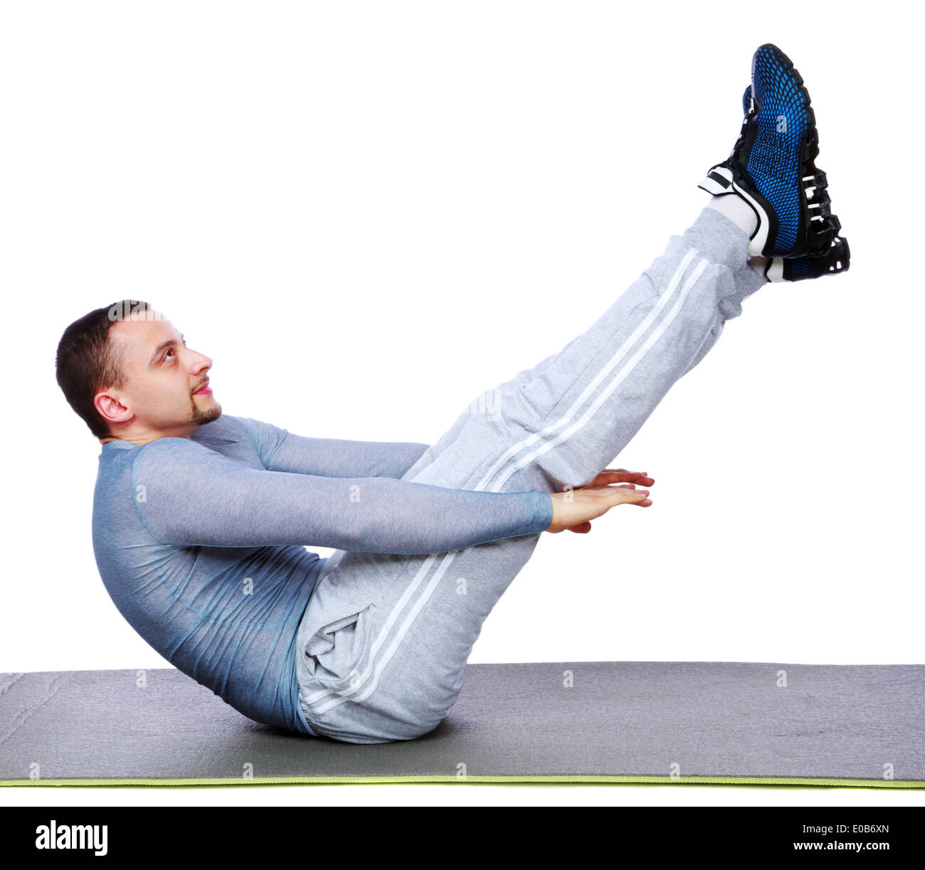 Muskulöser Mann Ausübung auf Gymnastikmatte auf weißem Hintergrund Stockfoto