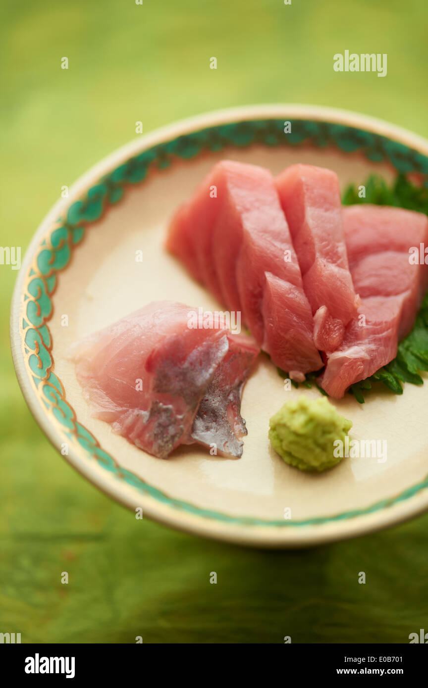 Stillleben mit roh in Scheiben geschnittenen Fischgericht mit Blätter Stockfoto