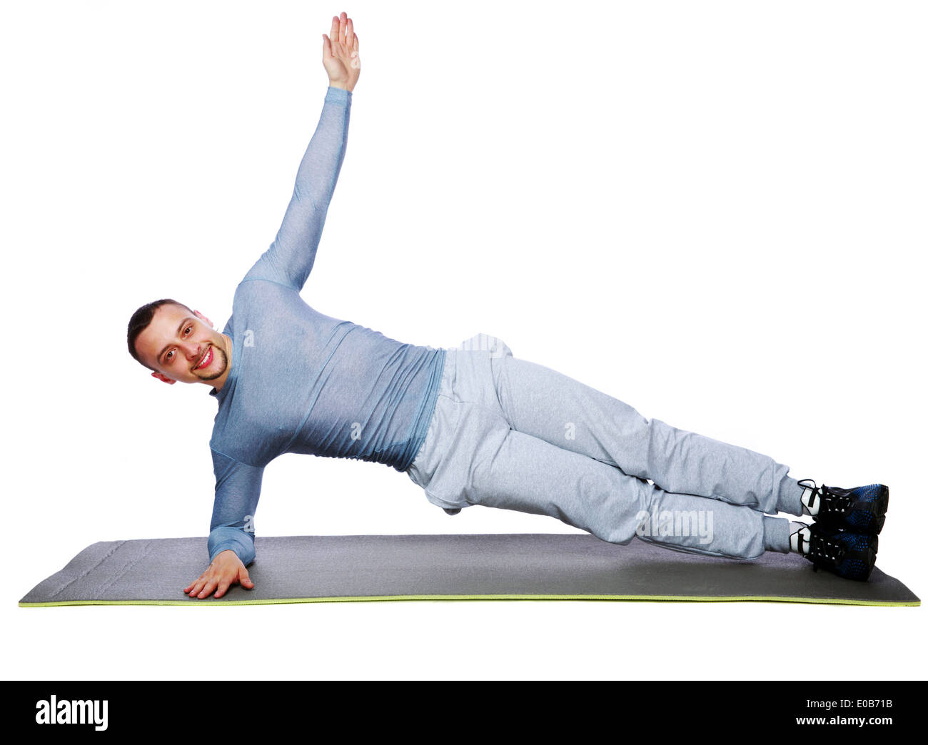 Muskulöse Sportler üben Yoga auf einer Matte auf weißem Hintergrund Stockfoto