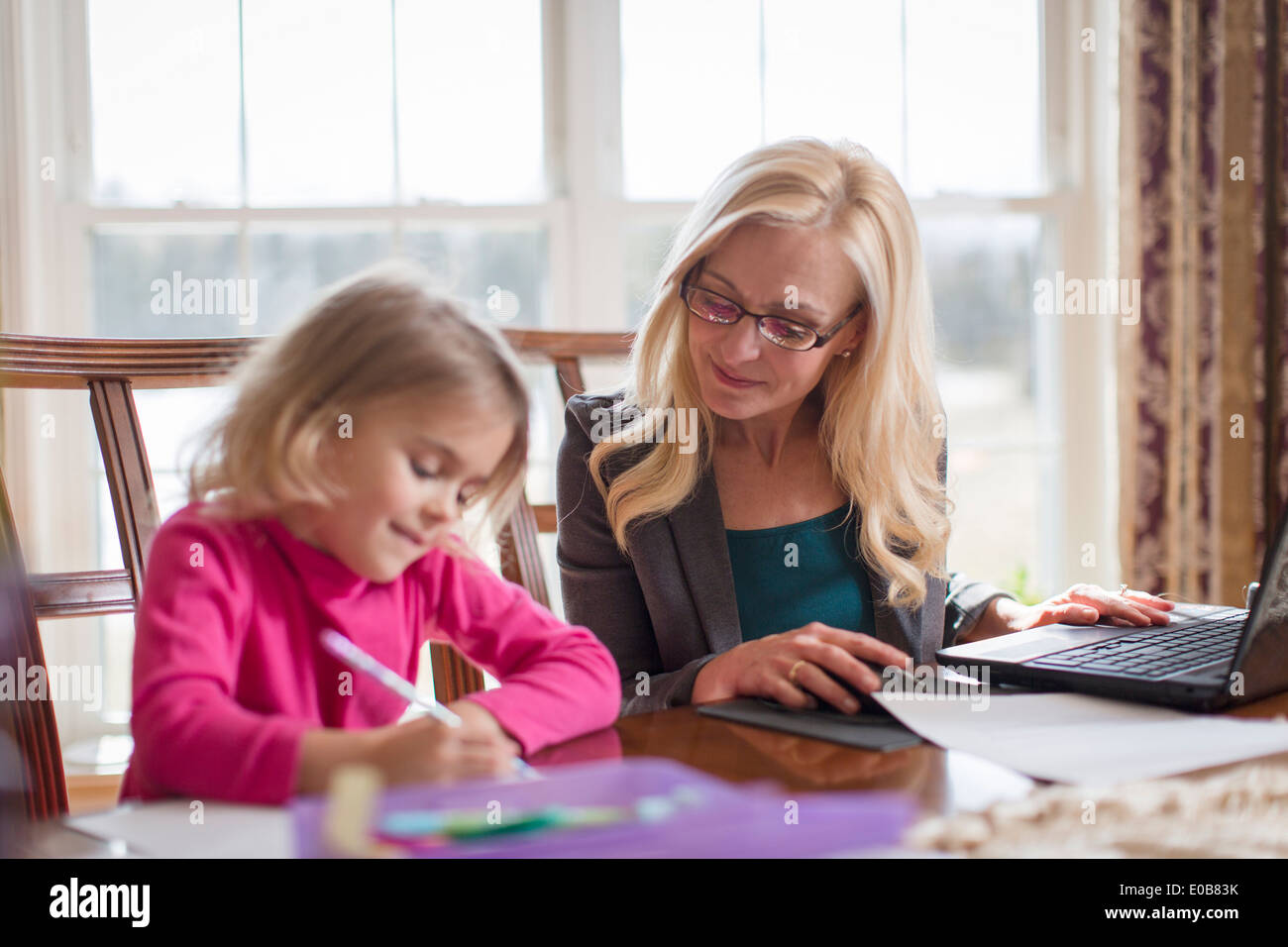 Mutter und junge Tochter tun, Arbeit und Hausaufgaben im Speisesaal Stockfoto