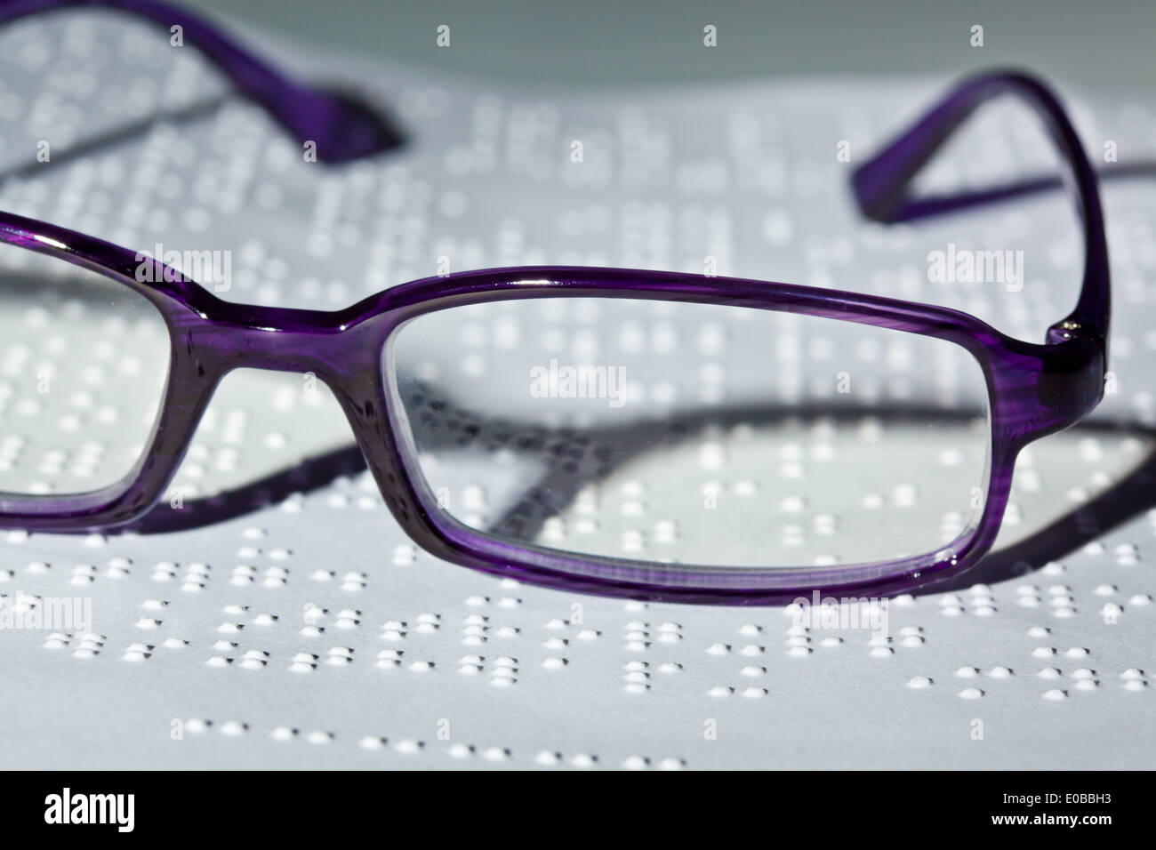 Gläser und ein Buch in Blindenschrift. Lesung mit Hindernis, Eine Brille Und Ein Buch in Blindenschrift. Lesen Mit Behinderung. Stockfoto