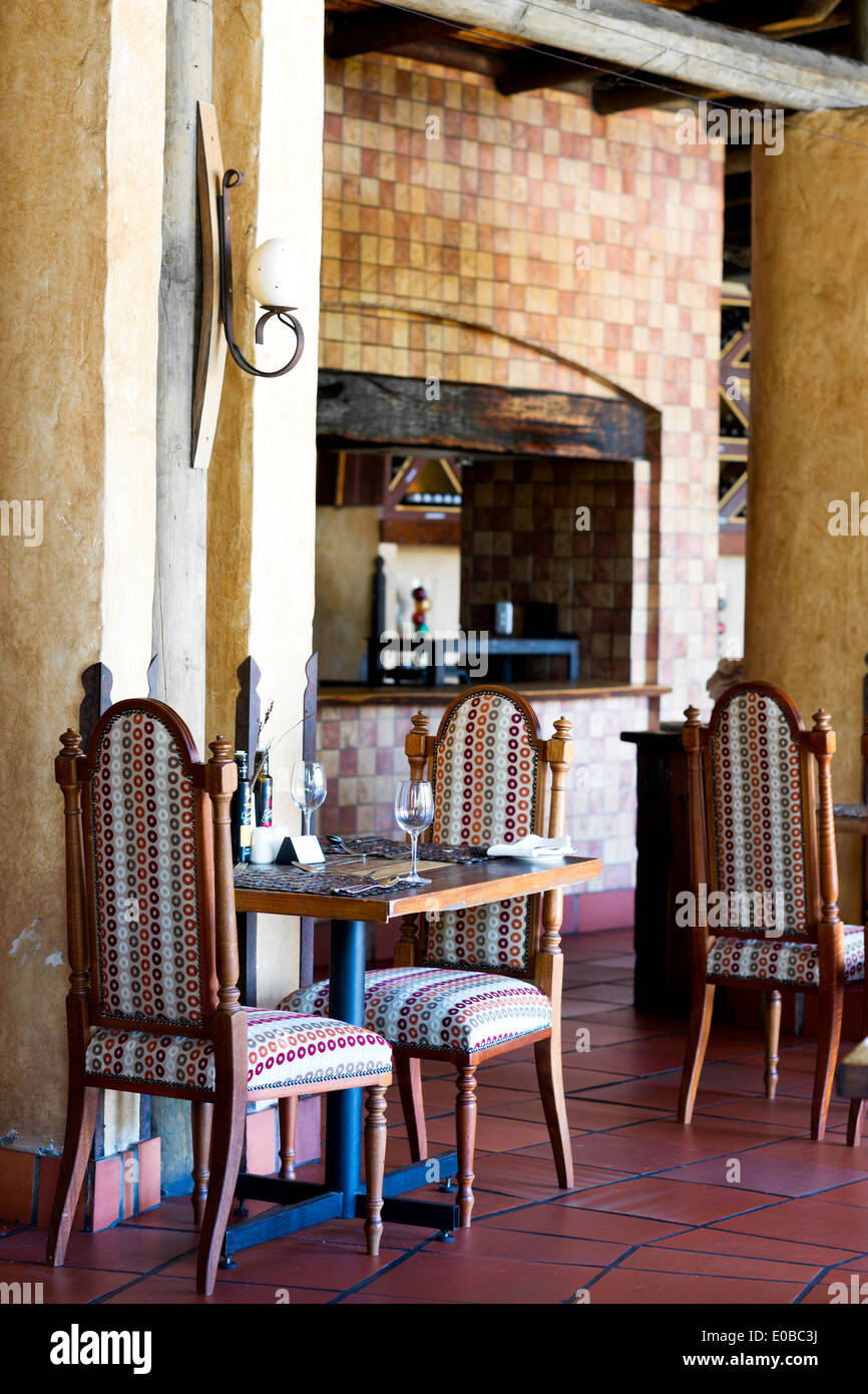 Inneren Speisesaal des Botleirskop Game Lodge mit Fliesenboden, Stoff print Stühle und Kachel Kamin Stockfoto