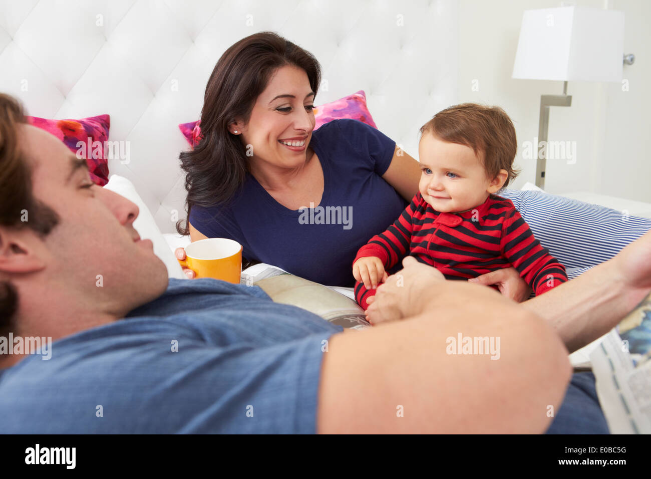 Familie entspannend im Bett mit Kaffee und Zeitung Stockfoto