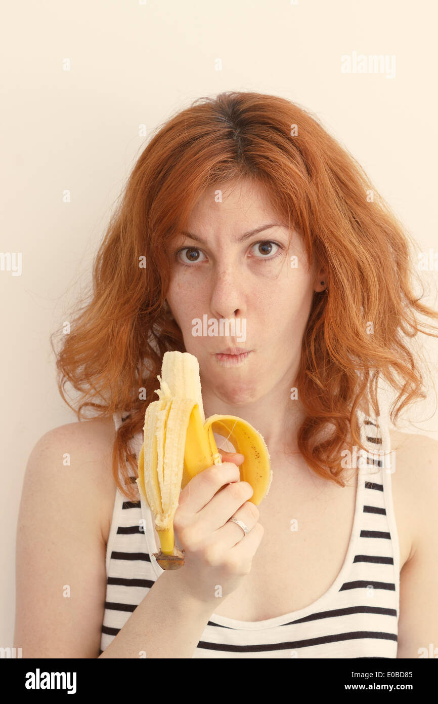 Junge Frau eine Banane essen Stockfoto