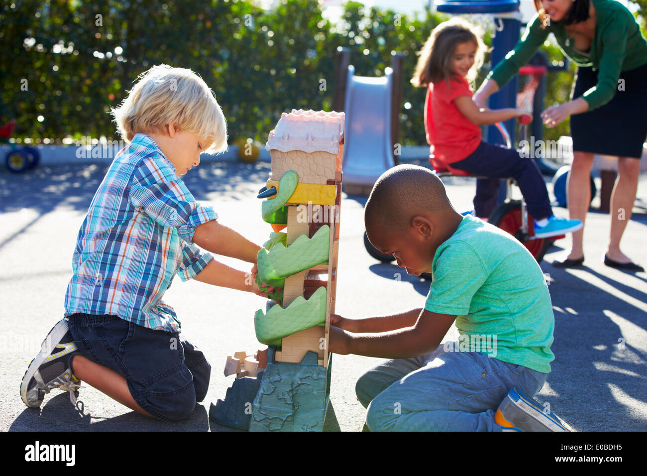 Zwei Jungs spielen mit Spielzeug auf Spielplatz Stockfoto