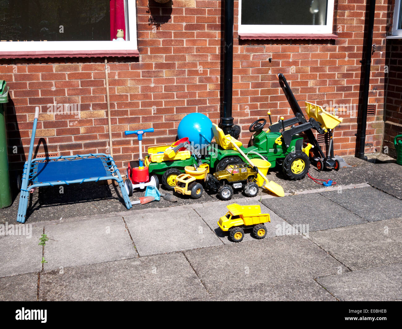 Jungen Spielzeug in gepflasterten Garten, England, UK. Stockfoto