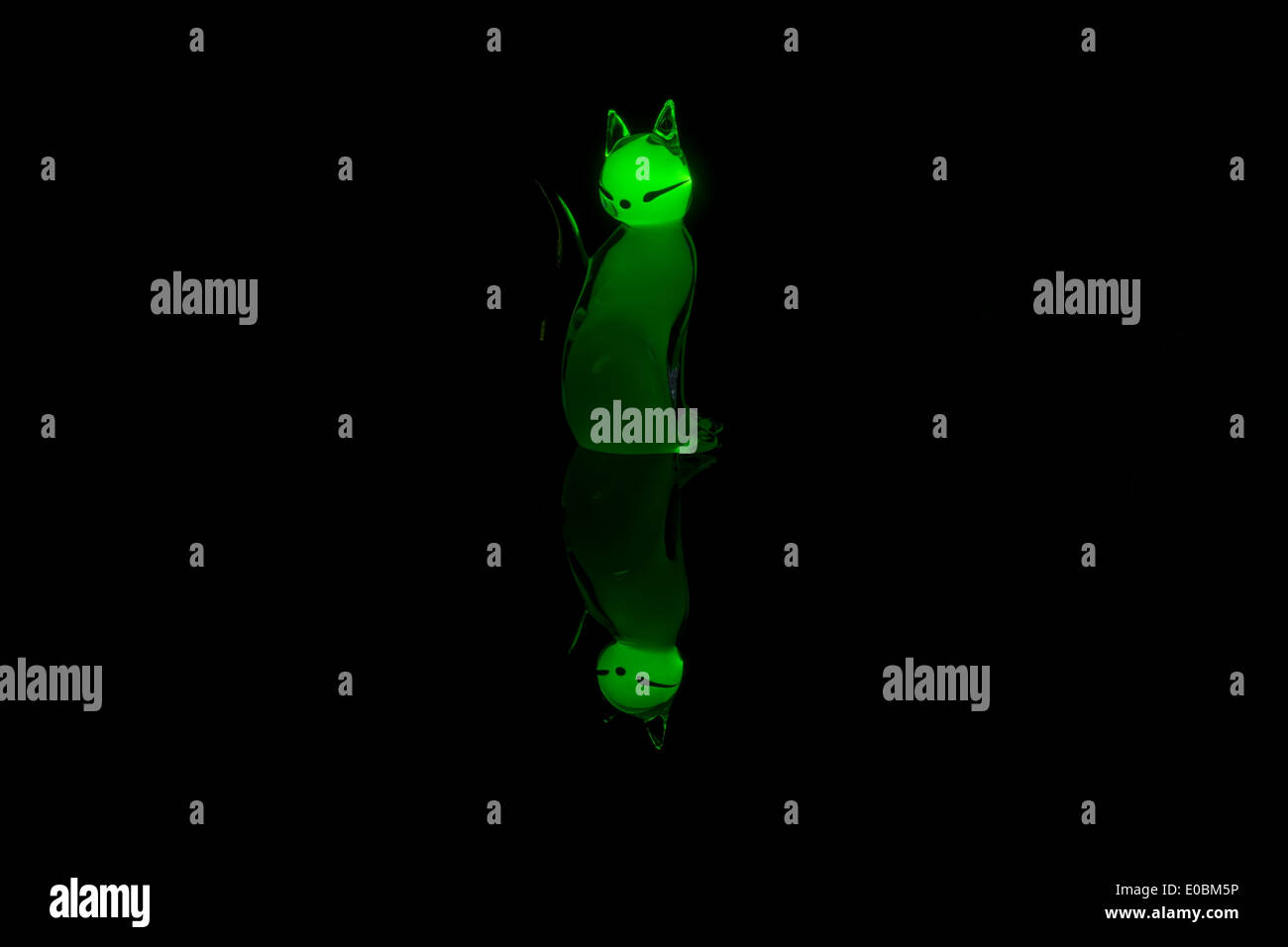 Katze aus Glas beleuchtet mit Laserlicht auf glänzendem Untergrund platziert Stockfoto