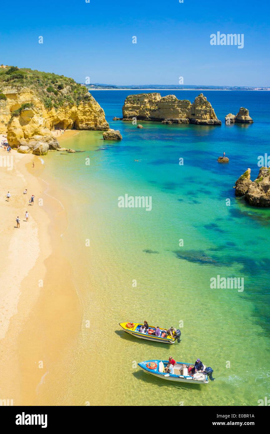 Urlauber und Touristenboote am Strand von Praia da Dona Ana Sandstrand in der Nähe der Ortschaft Lagos Algarve Portugal EU Europa Stockfoto