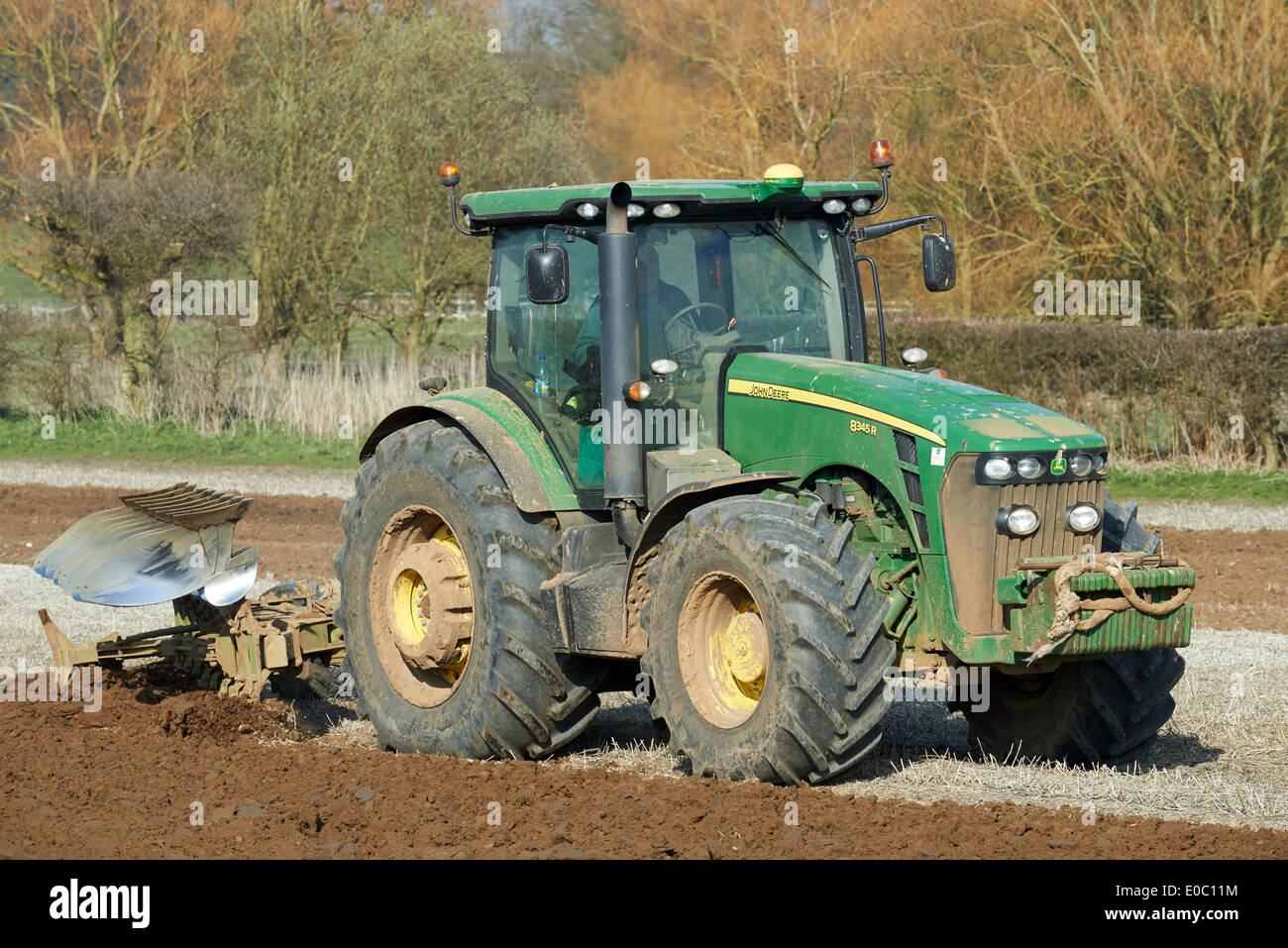 John Deere 8345R Traktor mit Pflug Stockfoto