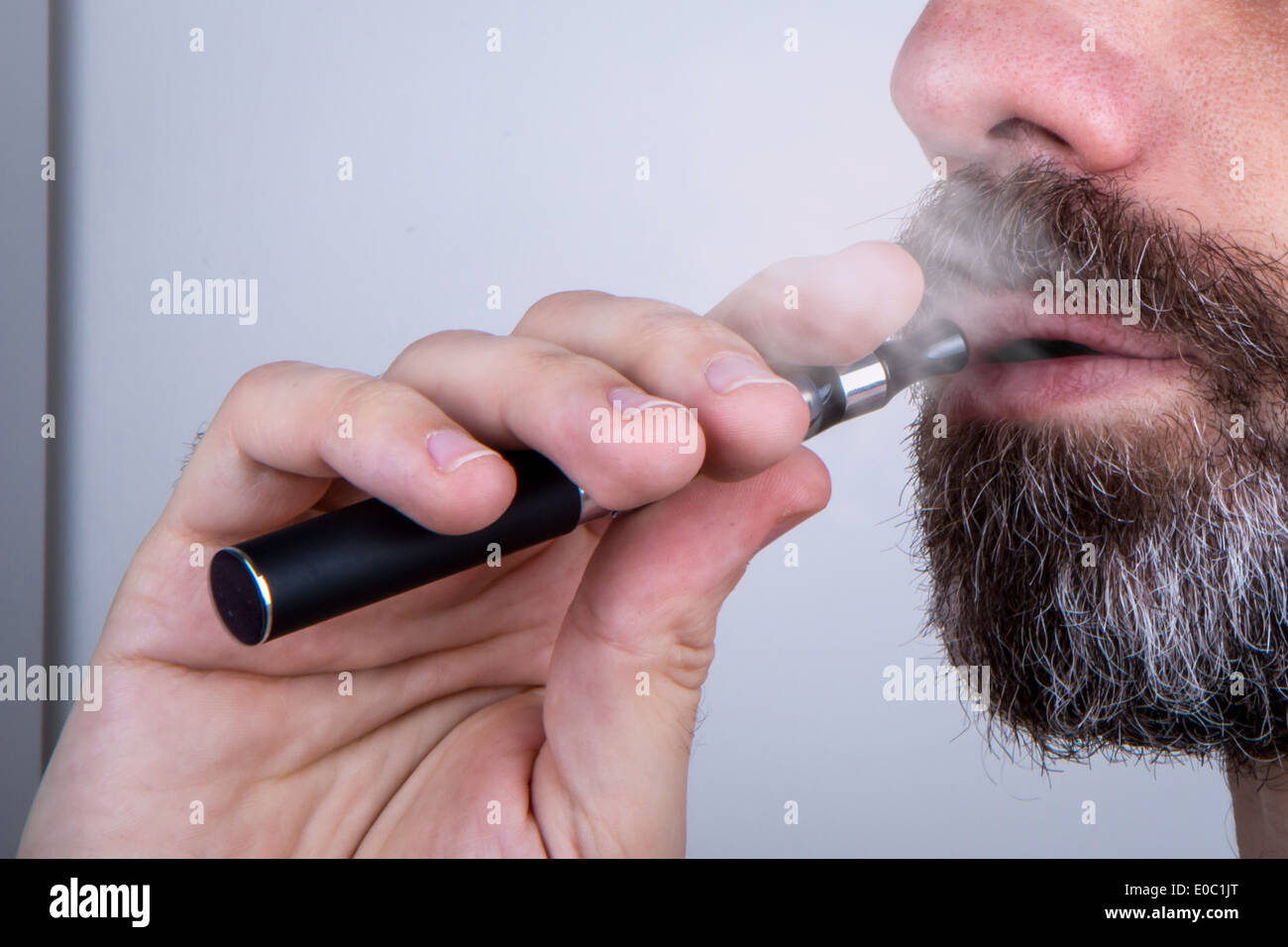 Bärtiger Mann mit einem Verdampfer (mit Dampf) Stockfoto