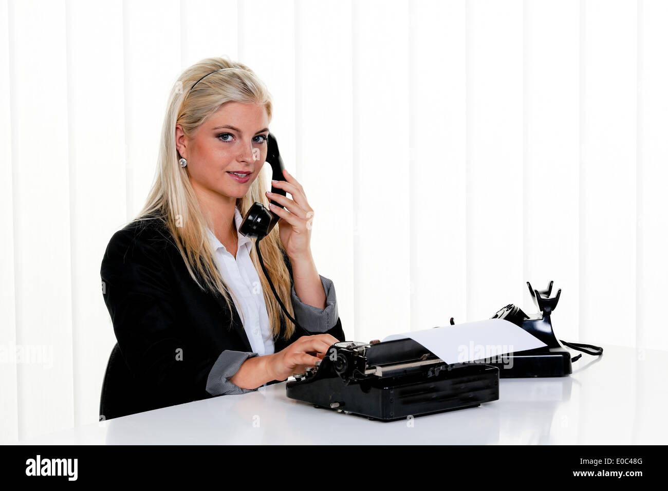 Junge Frau mit einem Telefon-Anruf im Büro., Junge Frau Bei Einem Telefonat Im Buero. Stockfoto