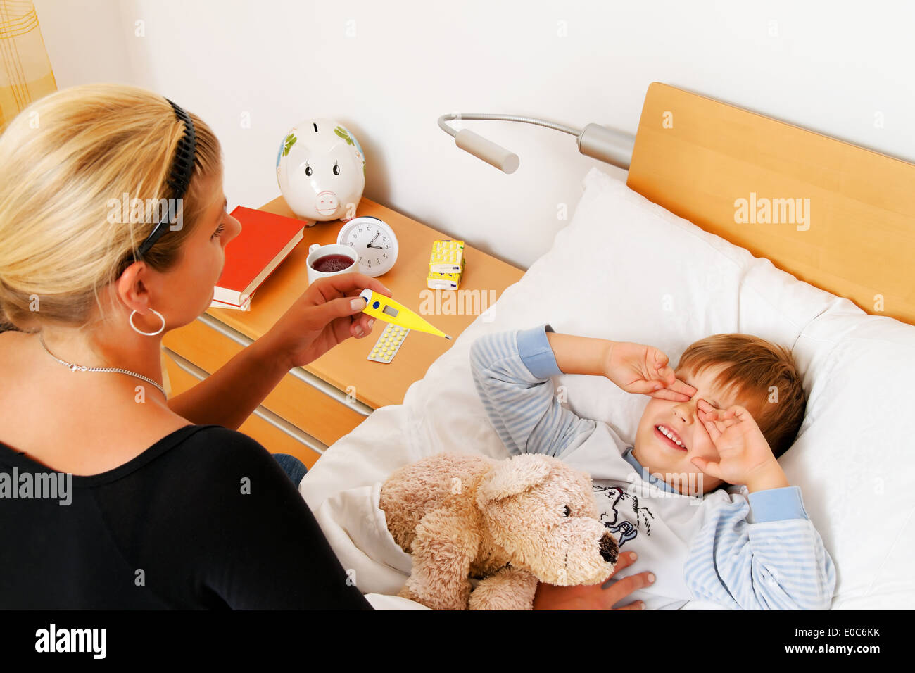 Eine Mutter und kranke Kind im Bett. Influenza. Kindheit Krankheiten., Eine Mutter Und Krankes Kind Im Bett. Grippe. Kinderkrankhei Stockfoto
